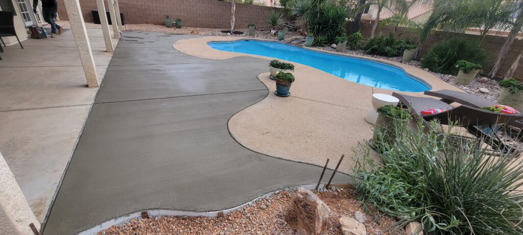 A pool with concrete steps and a cement walkway.